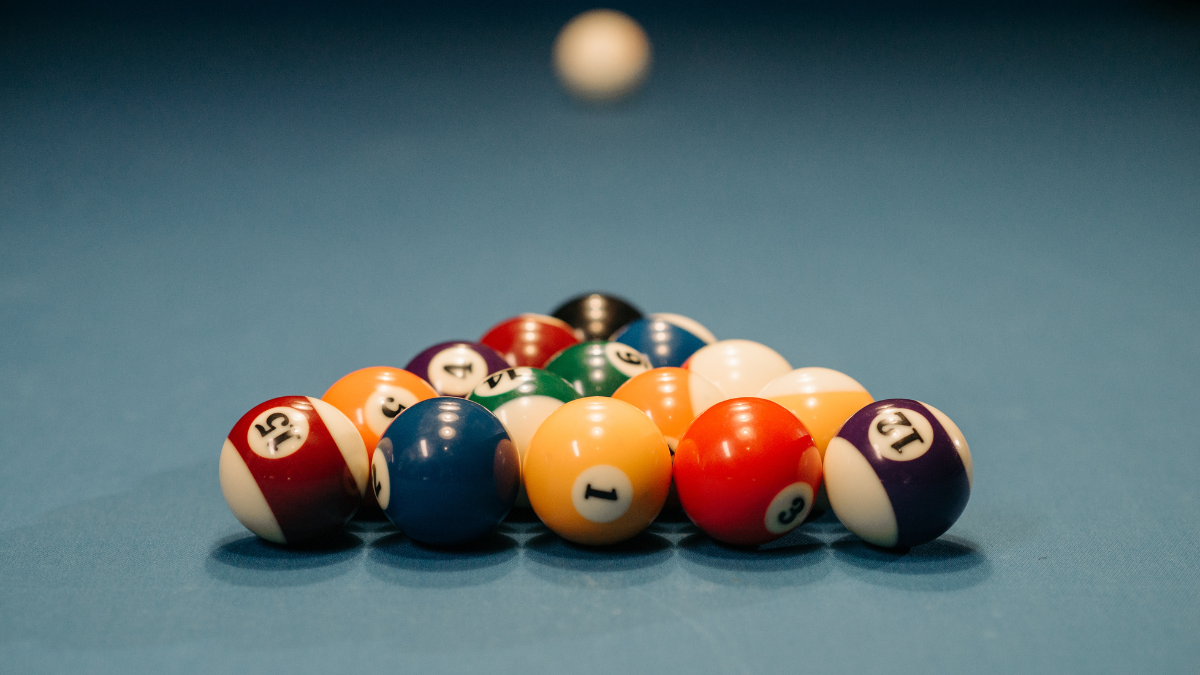 This image features a classic triangle formation of pool balls on a blue felt table, ready for a break.