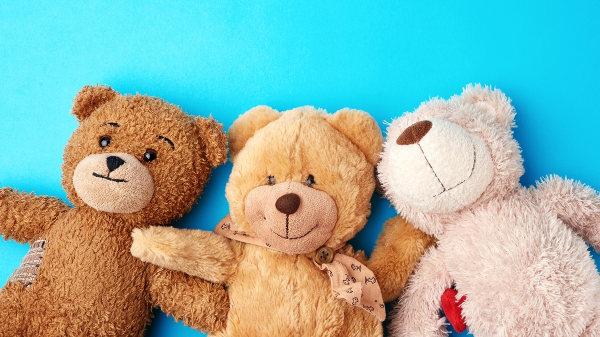 hree adorable plush teddy bears in various colors against a bright blue background, showcasing the soft textures and cute facial expressions of each bear.