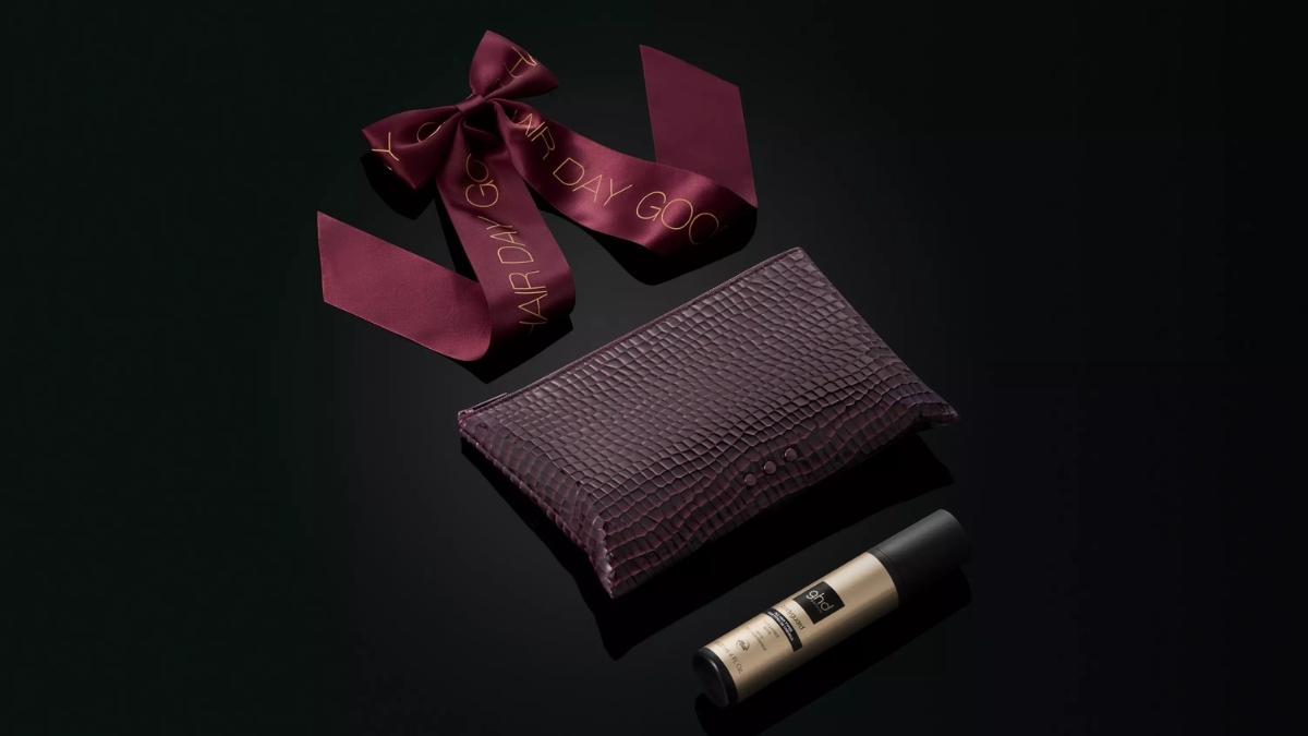 Elegant ghd hair styling gift set featuring a textured purple pouch, maroon ribbon with gold lettering, and ghd hair product bottle — showcasing premium accessories from The Ultimate Guide to ghd Hair Styling Products.