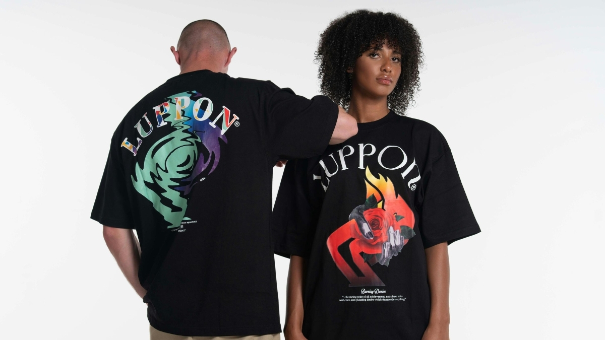 Two models wearing oversized black graphic streetwear t-shirts with bold colorful designs on the front and back.